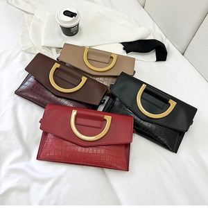 Detail of elegant crocodile pattern envelope bags in four colors with gold metal buckles