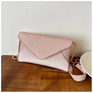 Detailed macro view of pink glitter envelope phone bag with golden metal chain strap