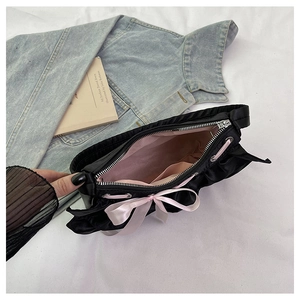 Detail of satin shoulder bag showing pink interior lining, pocket and ribbon bow