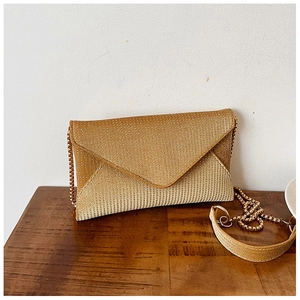 Macro view of gold rhinestone envelope clutch showing glitter texture and metal chain