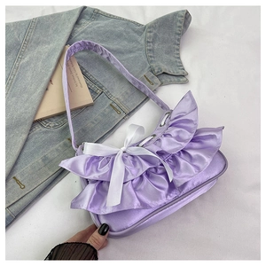 Detail of lavender satin shoulder bag with ruffled mesh trim and white ribbon bow