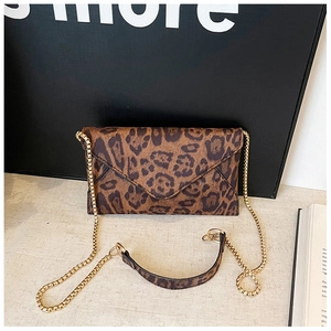 Close-up of leopard print envelope clutch bag with gold chain strap and suede texture