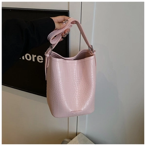 Detailed view of pink crocodile pattern bucket bag with fine stitching and silver hardware