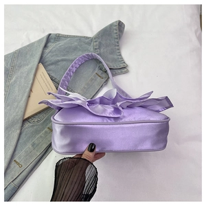 Detailed view of the purple satin handbag featuring elegant ruffle pleated decorations