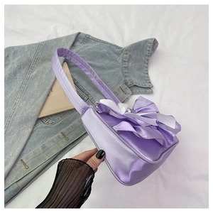 Close-up of light purple satin shoulder bag with oversized ribbon bow decorations