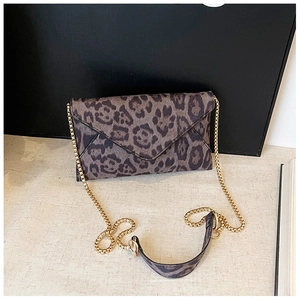 Detail of leopard print envelope bag featuring golden chain strap and soft faux fur texture