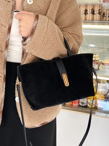 Retro black matte tote bag with gold metal buckle shown on a shoulder for daily commute