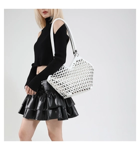 Détail du sac cabas en cuir blanc avec clous métalliques argentés et bandoulière style punk