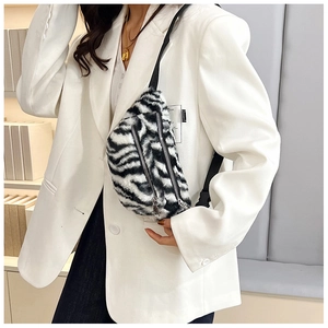 Detail of zebra print faux fur crossbody bag with dual silver zippers and plush texture