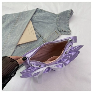 Top view of purple satin handbag showing interior lining, side pocket and bow detail