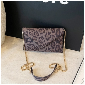 Detail of leopard print envelope clutch featuring golden chain and leather shoulder strap
