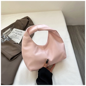 Detalle de un bolso hobo creciente rosa claro con costuras verticales y acabado mate