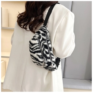 Rear view of model wearing a zebra print faux fur waist bag with dual silver zippers