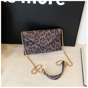 Close-up of leopard print envelope clutch with gold chain strap and shoulder pad