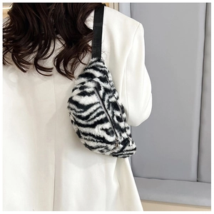 Close-up of zebra print faux fur crossbody bag with silver zippers and black nylon strap