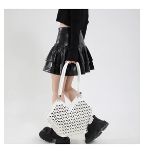 Sac à bandoulière blanc chic avec clous argentés porté par un mannequin au style punk