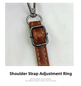 Detail of adjustable brown leather shoulder strap with stitching and gunmetal buckle