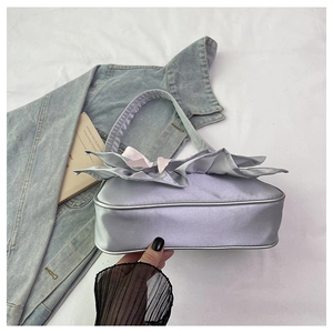 Detail showing smooth silver-purple satin fabric with pink bow and ruffled edges
