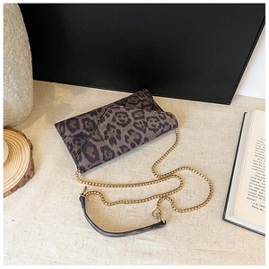 Detailed view of leopard print envelope clutch featuring a gold chain and soft texture