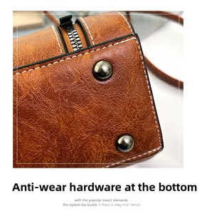 Close-up of bottom wear-resistant silver hardware feet on brown leather shoulder bag