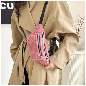 Detail view of pink teddy fleece crossbody bag featuring dual silver metal zippers