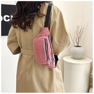 Detail showing plush pink sherpa fanny pack texture with black zipper and adjustable strap