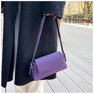 Deep purple frosted underarm bag with shoulder strap shown on a black coat outfit