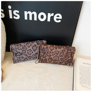Detail of leopard print envelope clutches with elegant gold chain straps and sleek trim