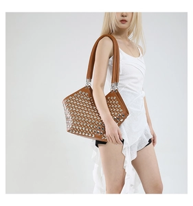 Sac cabas en cuir marron avec clous en métal argenté porté par un mannequin