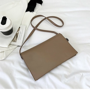 Top view of a minimalist khaki rectangular crossbody bag on a clean white fabric background