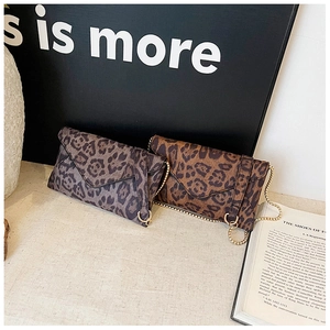 Detail view of leopard print envelope clutch bags with gold metal chain straps
