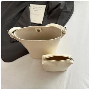 Detailed view of white crocodile pattern bucket bag set with matching zipper pouch