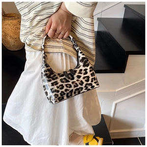 Close-up of leopard print patent leather hobo bag with sleek dual zippers and top handle
