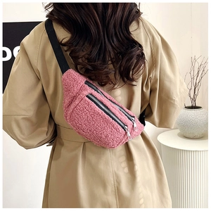 Pink teddy fleece crossbody bag featuring a dual zipper design and adjustable strap detail