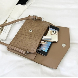 Brown crocodile embossed clutch showing large capacity for tablet, phone and cosmetics