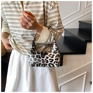 Detail of glossy leopard print hobo bag with patent leather texture and handle