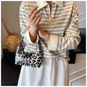 Detail shot of a glossy leopard print hobo bag with high-end texture and zip closure
