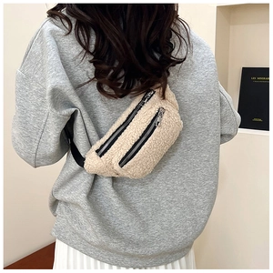 Detailed texture of beige teddy fleece waist bag with double zippers and black strap