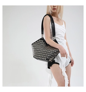 Vue détaillée du sac cabas en cuir noir orné de rivets métalliques argentés denses