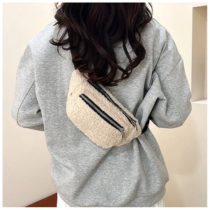 Detailed back view of model wearing a fluffy off-white teddy fleece crossbody chest bag