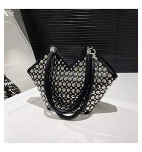 Vue détaillée d'un sac cabas noir orné de clous argentés et d'une ouverture en forme de V