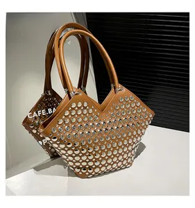Détail du sac cabas en cuir caramel avec rivets métalliques argentés et forme géométrique