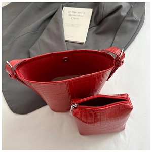 Detail view of red crocodile pattern bucket bag set with silver hardware and inner pouch