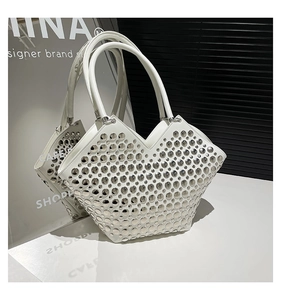 Gros plan sur les rivets argentés du sac cabas blanc au design punk sophistiqué