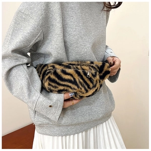Detail showing the soft faux fur texture and silver metal zipper of the animal print bag