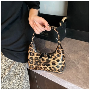 Detail of glossy leopard print patent leather bag with dual zipper and sleek texture