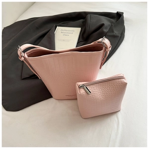 Detailed close-up of pink crocodile pattern bucket bag and matching inner pouch set