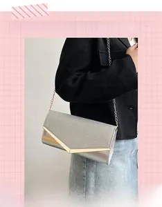 Close-up of glitter silver clutch bag with elegant gold V-shaped metal trim and chain strap