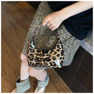 Close-up of the glossy patent leather leopard print texture on a vintage hobo bag