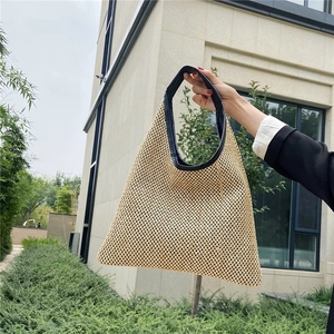 Retro woven straw tote bag with black leather trim and handles for summer beach holidays